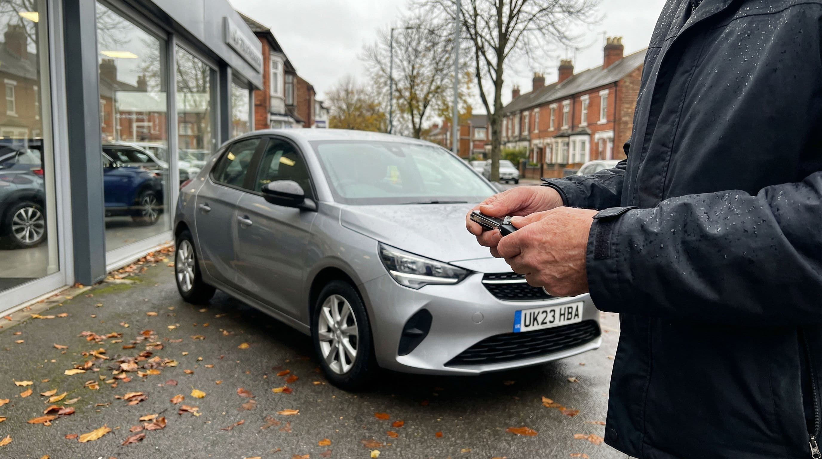 Car owner holds keys outside dealership considering finance options