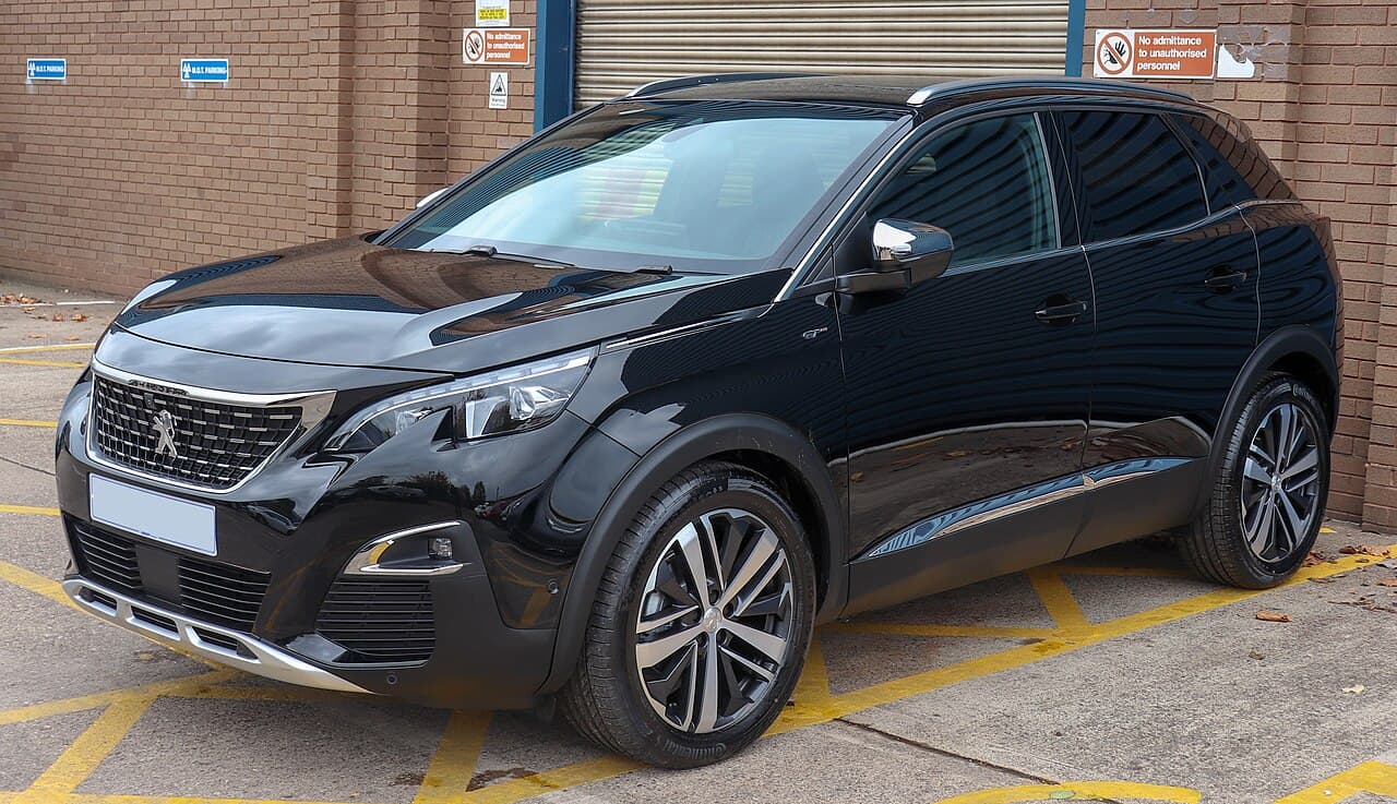 A black 2018 Peugeot 3008 parked outside a brick building