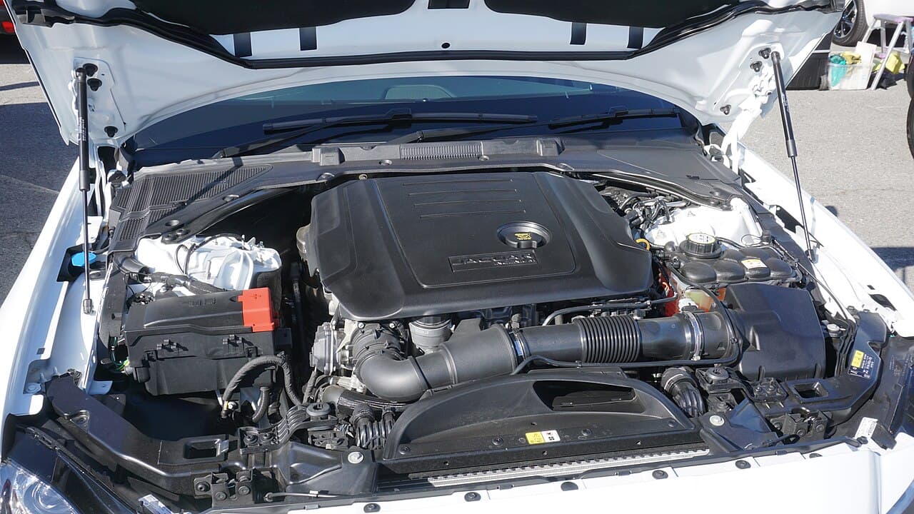 The 2.0 Ingenium diesel engine under the open bonnet of a white Jaguar XF 20d