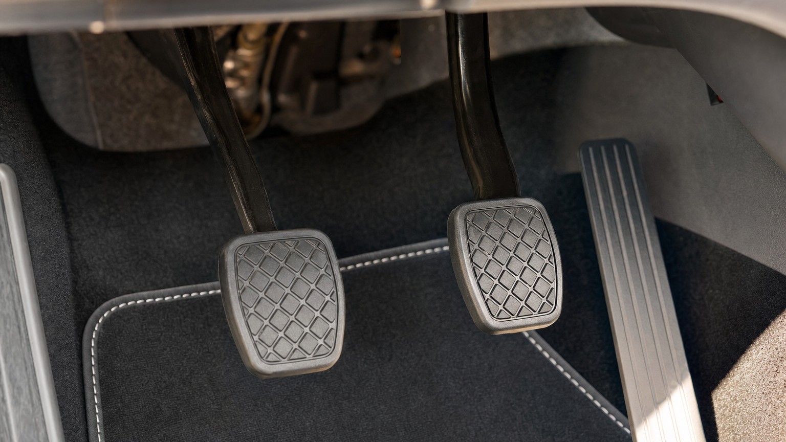 The clutch, brake and accelerator pedals in a car footwell